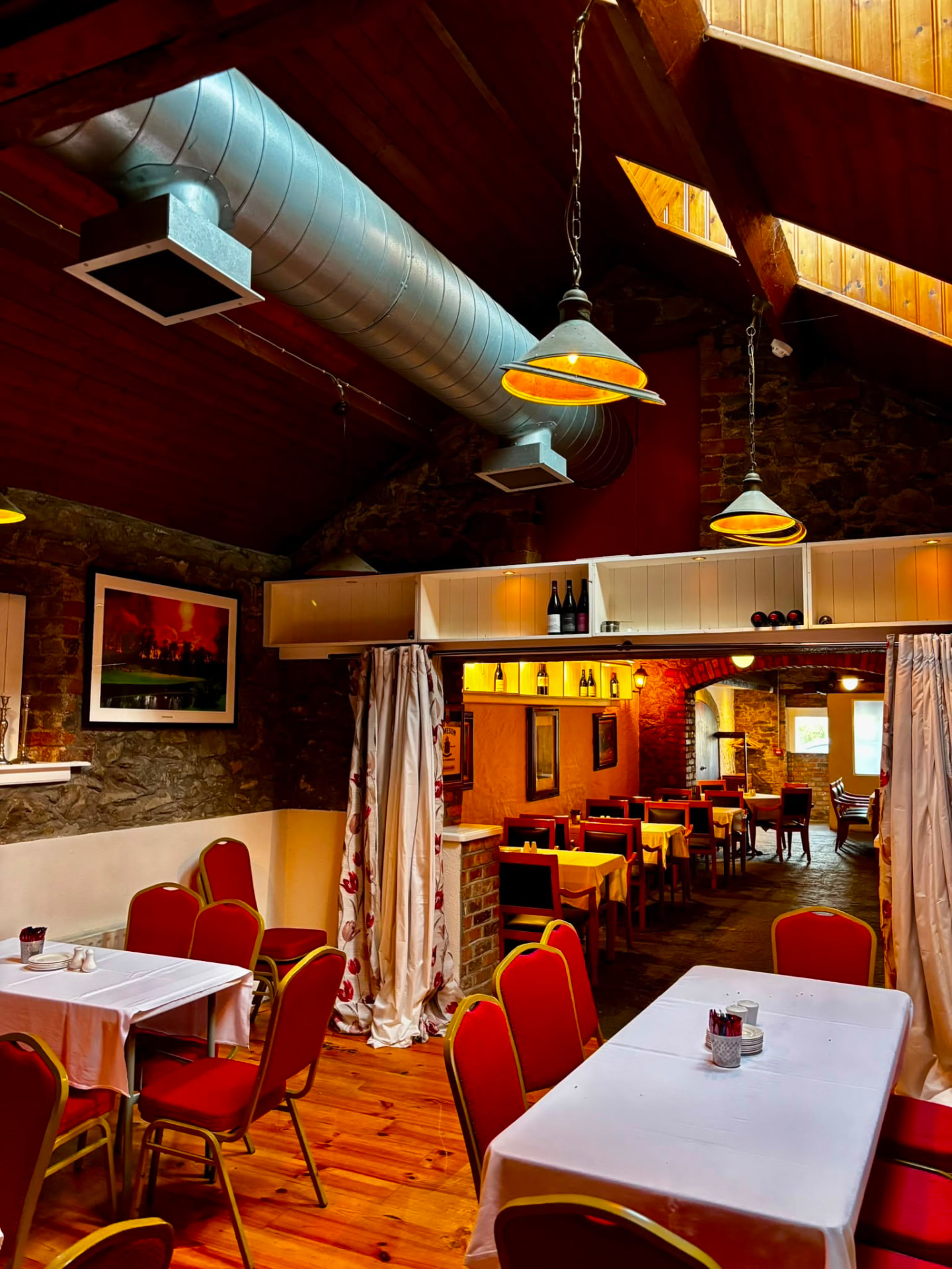 The King's Quarters dining room with red chairs and white tablecloths